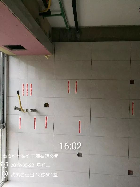 南京武夷名仕園124平米簡美風(fēng)格裝修  享受家?guī)淼臏囟?0五月份_墻磚鋪貼完成后，紅牛裝飾的工人會(huì)用專用護(hù)角條對瓷磚角保護(hù)，用標(biāo)貼標(biāo)出水管、線管走向示意。